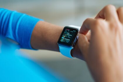 Person interacting with a smartwatch, showing a fitness application on the screen.