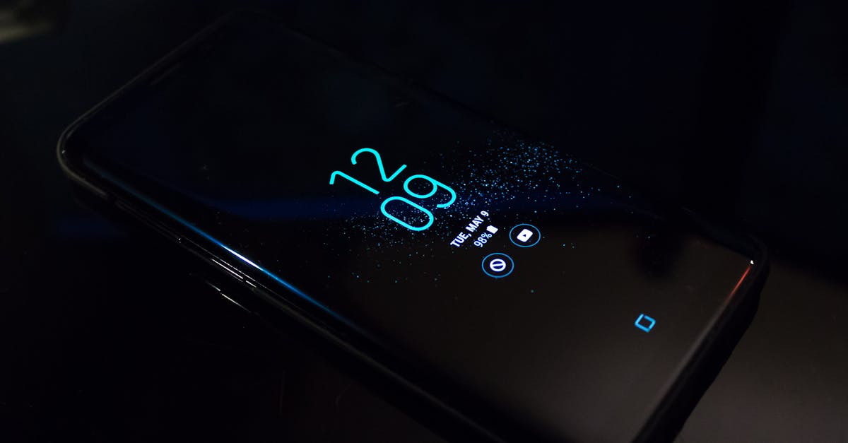 Close-up of a smartphone in the dark displaying digital clock and notifications.