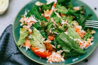 A vibrant green salad featuring mixed vegetables on a blue plate.