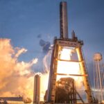 A dramatic shot of a SpaceX rocket launch against a colorful dusk sky, depicting power and technology.