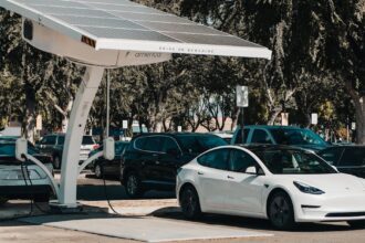 Electric car parked at a solar charging station outdoors, highlighting renewable energy and innovation.