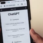 Close-up of hands holding a smartphone displaying the ChatGPT application interface on the screen.