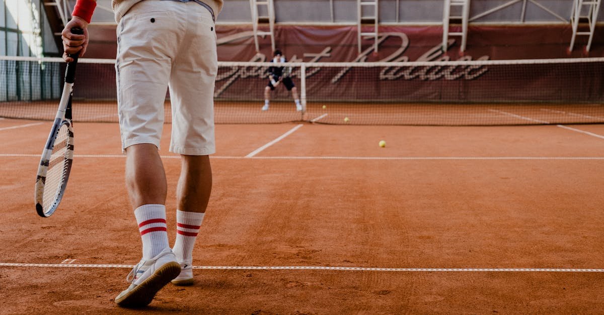 Players competing in a tennis match on an indoor clay court.