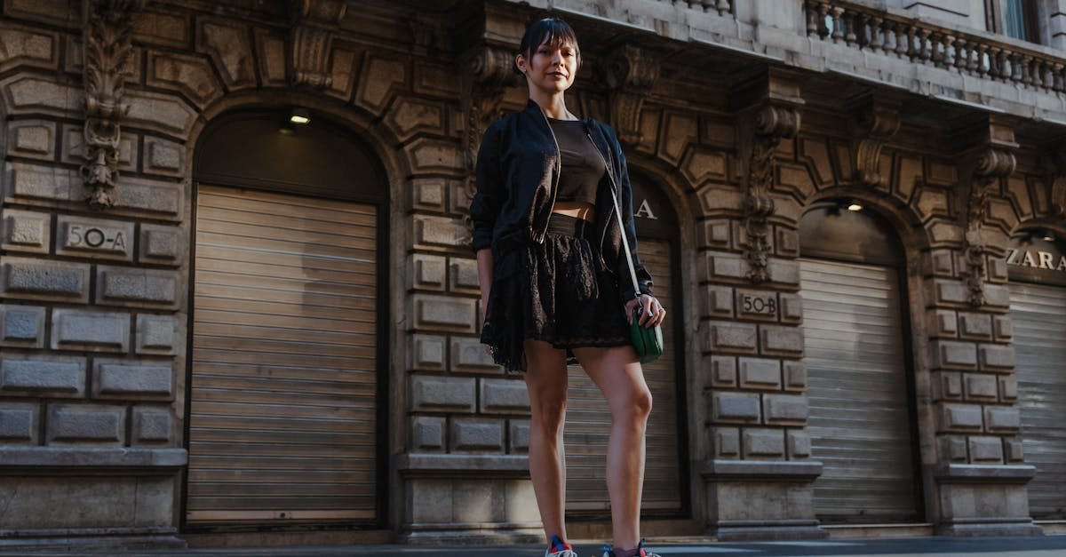 A stylish woman poses confidently on a city street, showcasing chic street fashion.