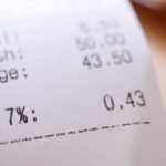 Detailed close-up image of a shopping receipt showing GST and total changes.