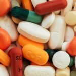 Close-up of assorted colorful pills and tablets on a surface.