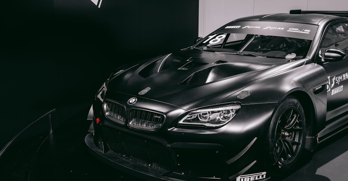 Black BMW racing car displayed in a Munich exhibition, showcasing modern automotive design.