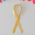 Colorful childhood cancer awareness ribbon isolated on a white background.