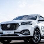 Low-angle shot of a white SUV on an open road in Islamabad, emphasizing its sleek design.