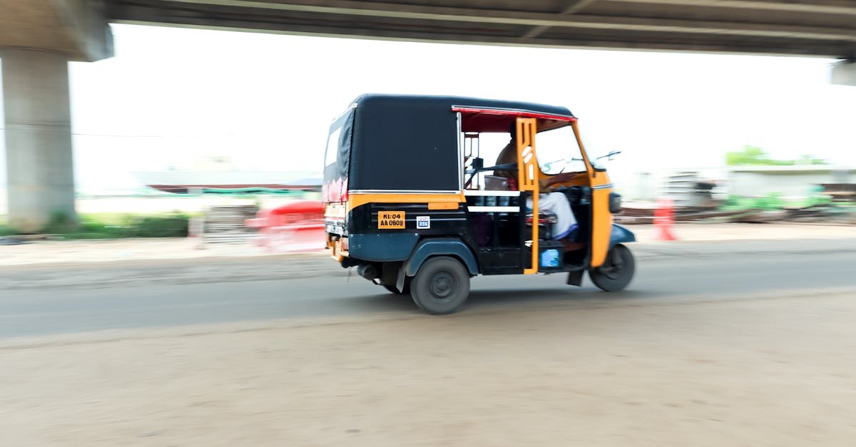 Auto rickshaw driving on a busy road in Kochi, Kerala, showcasing motion blur and speed.