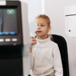 Young girl covering one eye during an optometric exam in a clinic setting.