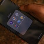 A hand holds a smartphone displaying popular payment apps for digital transactions.