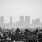 Black and white view of a historic church with Los Angeles skyline enveloped in fog and smog.