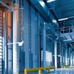 Spacious and modern warehouse interior with parked truck and steel structures.