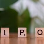 Wooden letter blocks spelling IPO on a table, symbolizing investment opportunities.