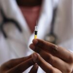 Close-up of a healthcare professional holding a syringe, symbolizing medical care and vaccination.