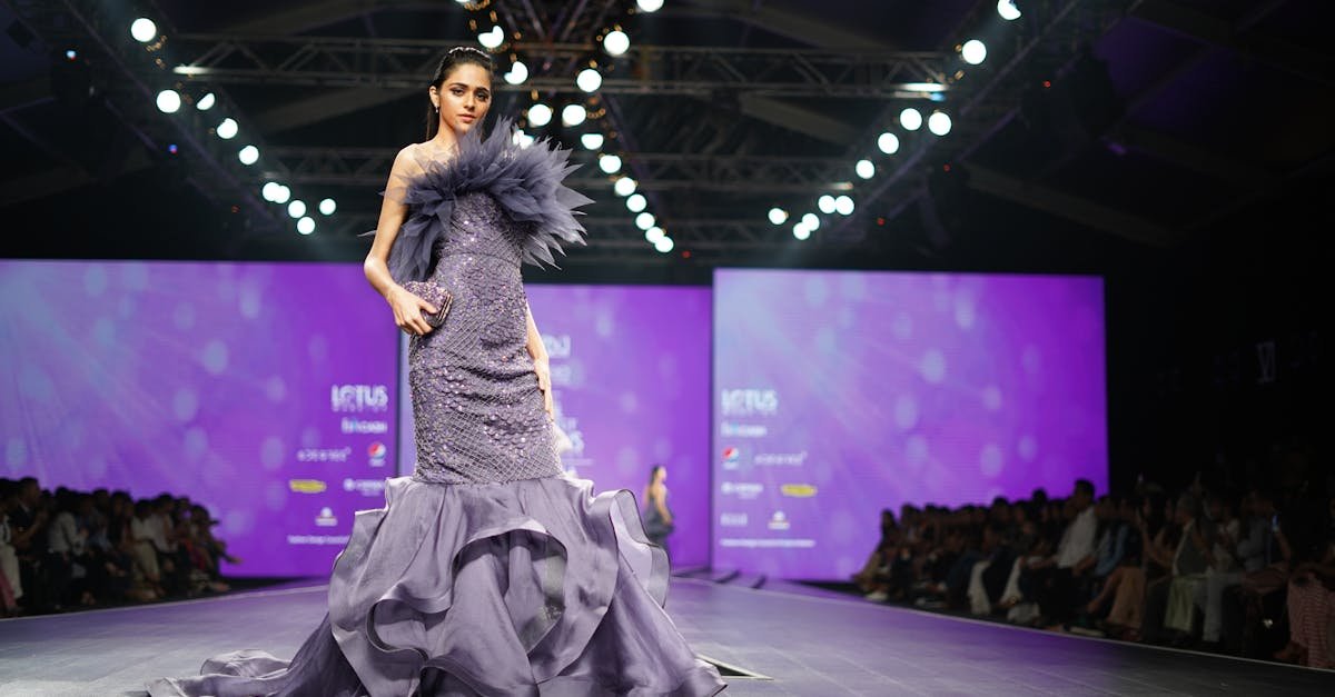 A model in a stunning purple gown walks the runway at a prestigious fashion event.