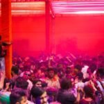 Lively celebration of Holi in Ludhiana, India with a colorful crowd enjoying the festival.