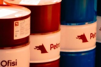 A collection of red and blue oil barrels labeled 'Petrol Ofisi' in an outdoor industrial setting in Turkey.