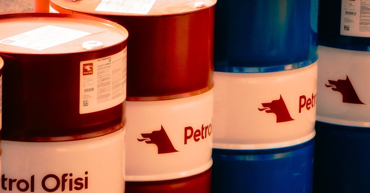 A collection of red and blue oil barrels labeled 'Petrol Ofisi' in an outdoor industrial setting in Turkey.